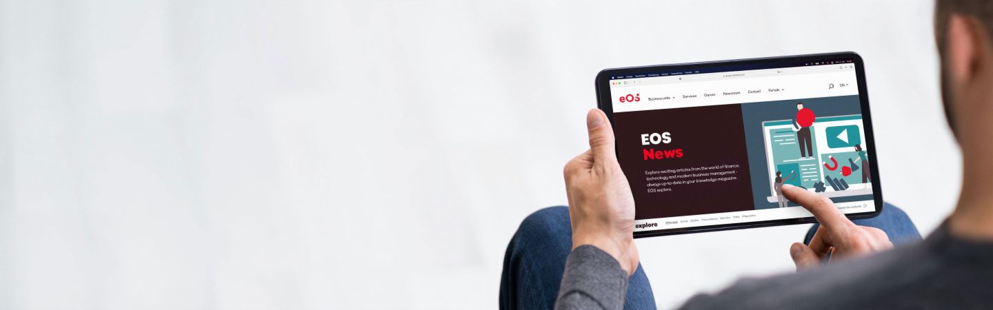 O persoană ține o tabletă pe care este deschis site-ul EOS Newsroom, oferind informații despre cele mai recente știri, articole online și comunicate de presă.